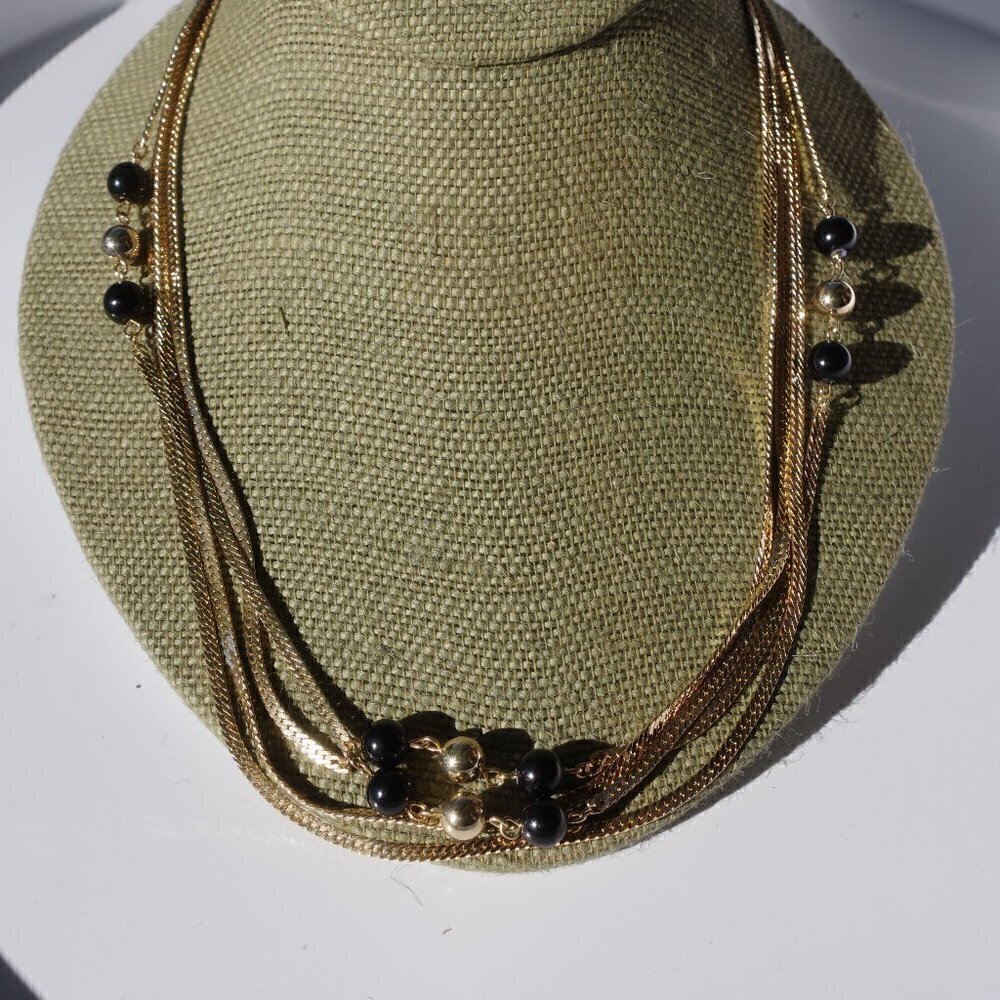 Women`s gold tone black/gold bead chain necklace.